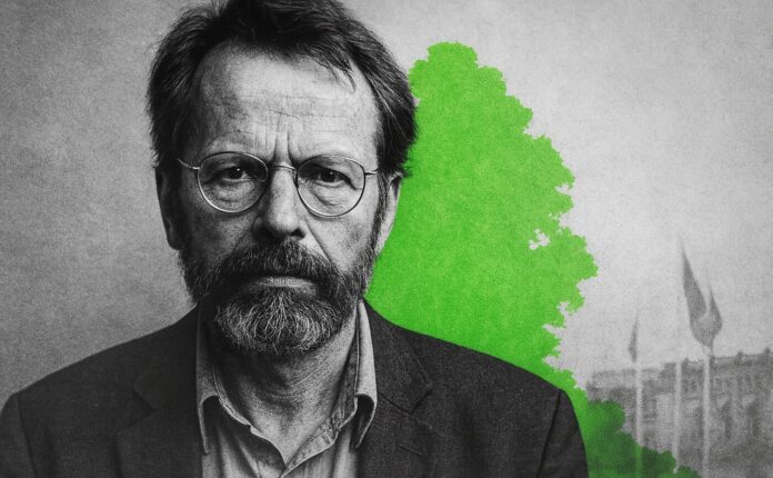 tom-koenigs Schwarzweiß-Porträt eines Mannes mit Brille und Bart vor grauem Hintergrund mit grünem Akzent